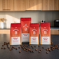aboum Rebellin Hilde Sortiment – alle drei Röstungen (Espresso, Crema, Filter) in 250g und 1kg auf schwarzer Küchentheke mit Kaffeebohnen